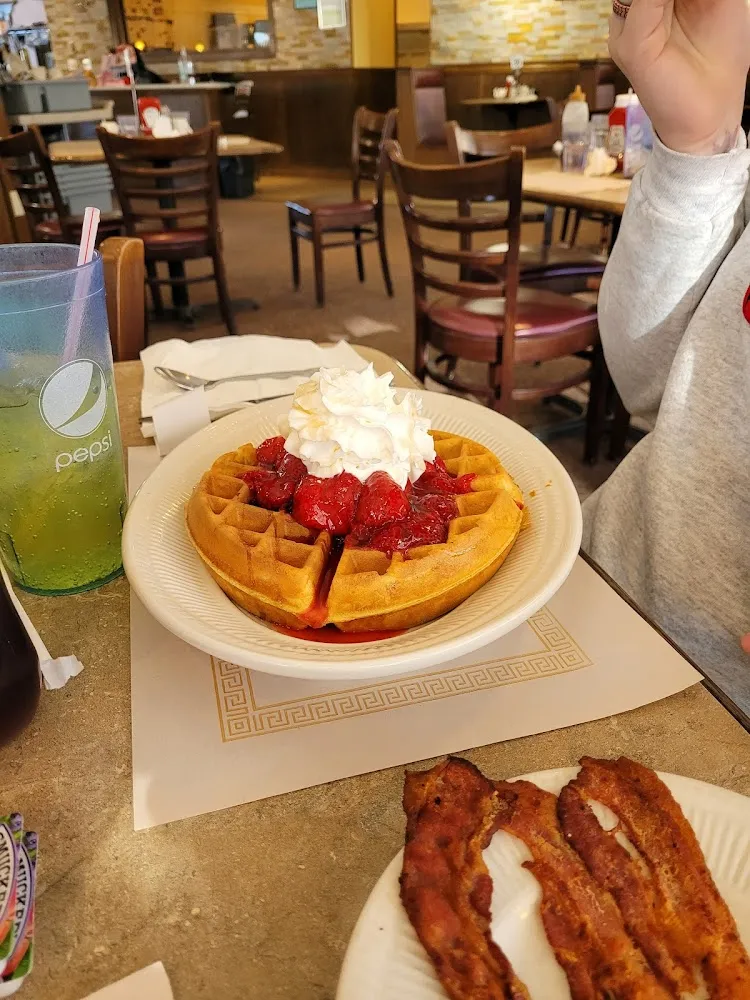 Alaskan Waffle with Pecans with Vanilla Ice Cream Topped with Strawberries Pecans and Whipped Cream